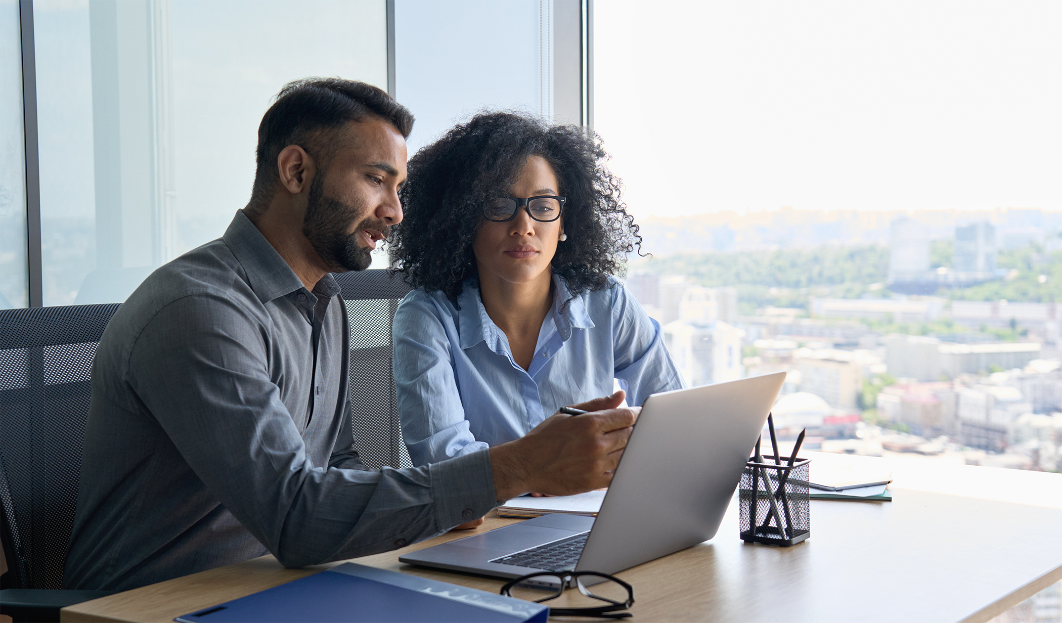 man and woman discussing content on laptop