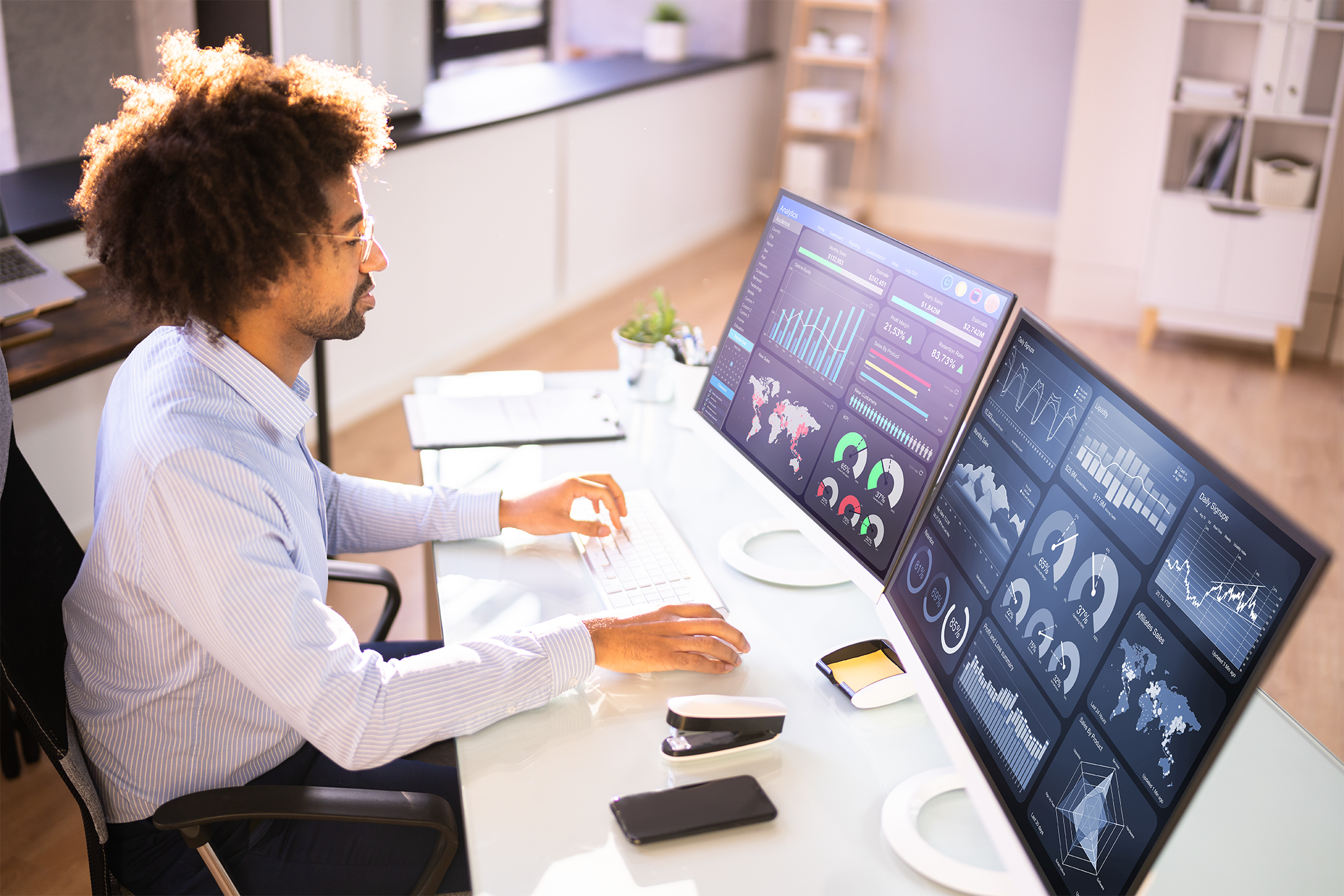 Man sitting at desk looking at computers