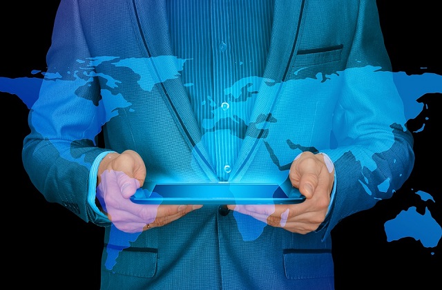 businessman holding tablet blue background