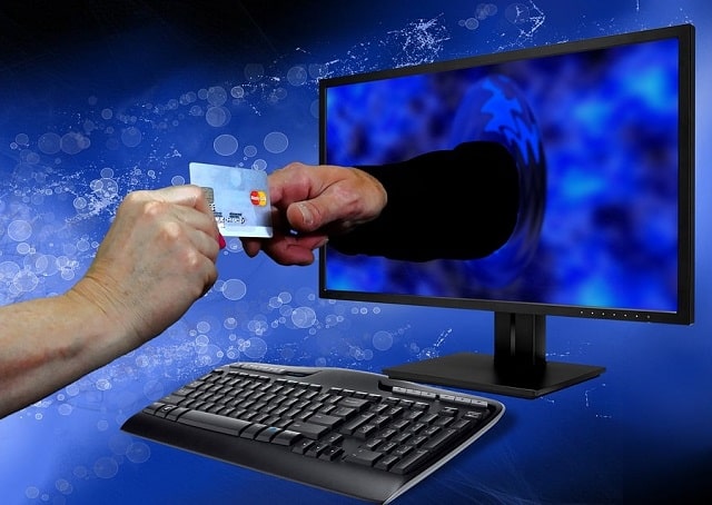 hands exchanging card through computer