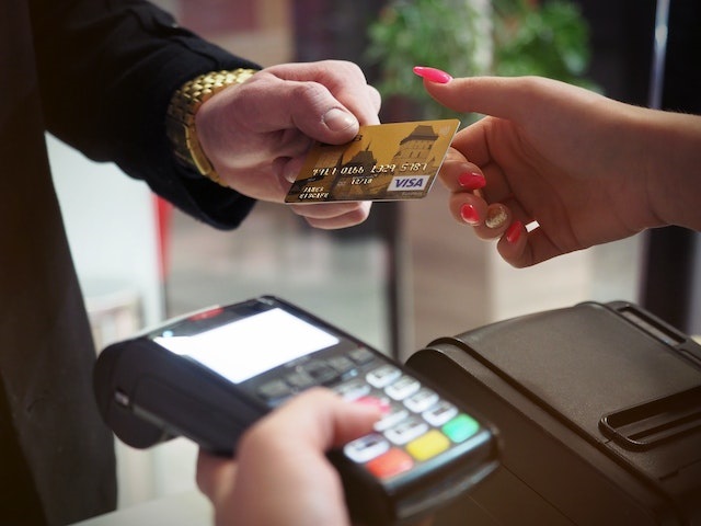 Person making a payment on a POS device with a payment card