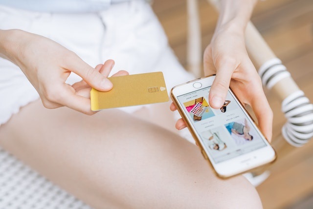 Person making an ecommerce purchase on their smartphone with a payment card