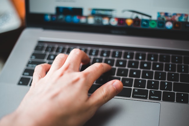 hand typing on laptop keyboard